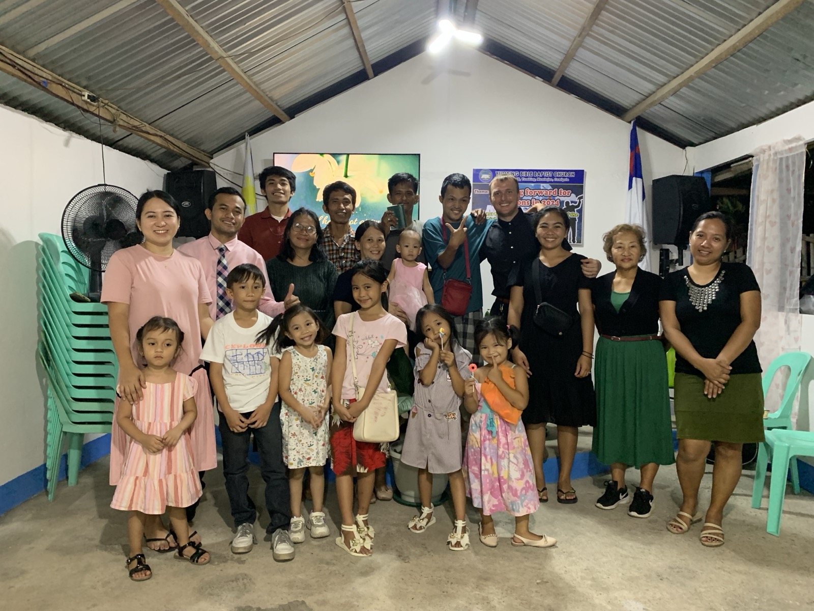 A Filipino Baptist church congregation gathered for a group photo with children and adults after a service