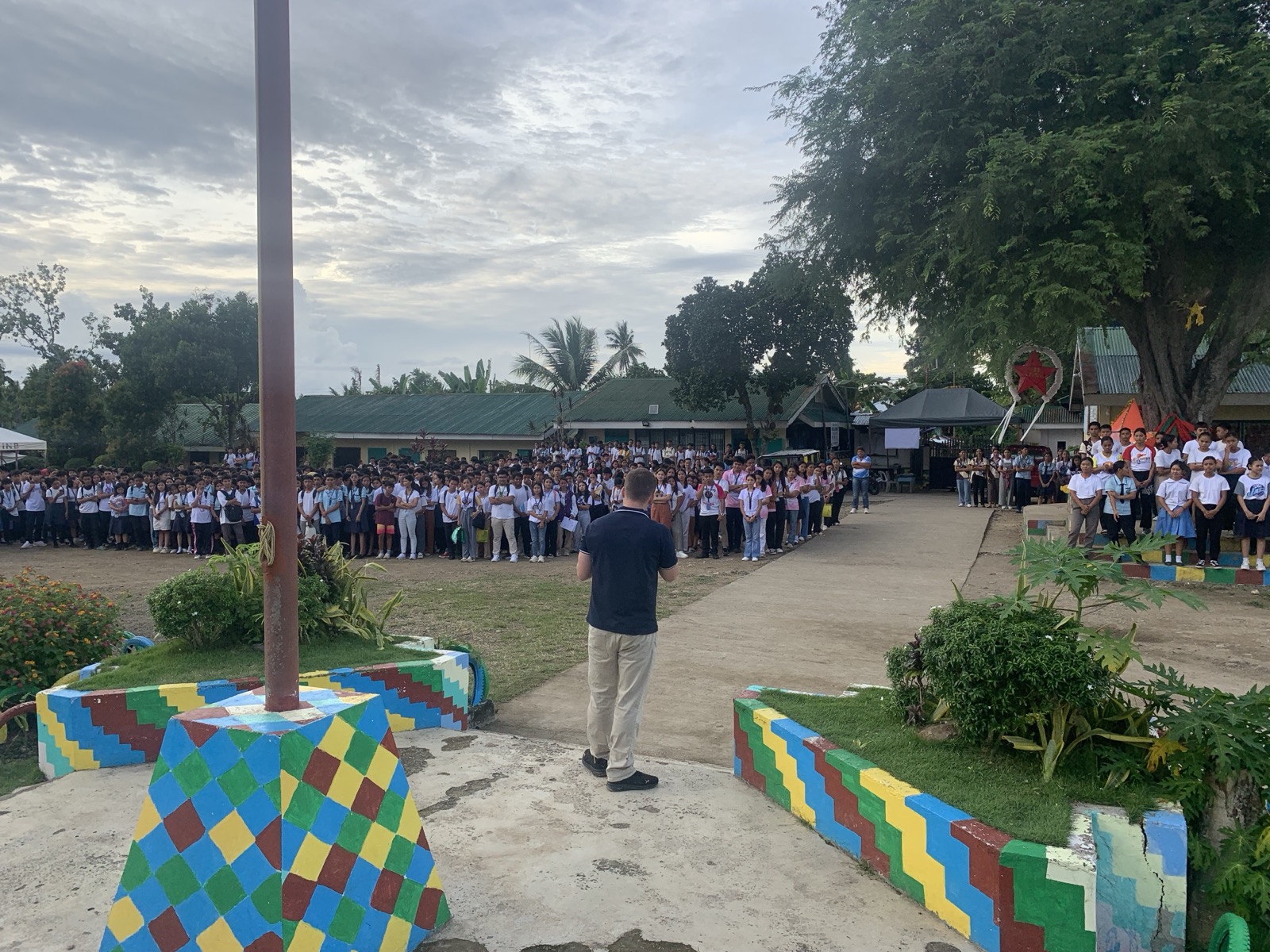 Collin preaching to a school-wide assembly of high school students gathered outdoors in Inabanga, Bohol